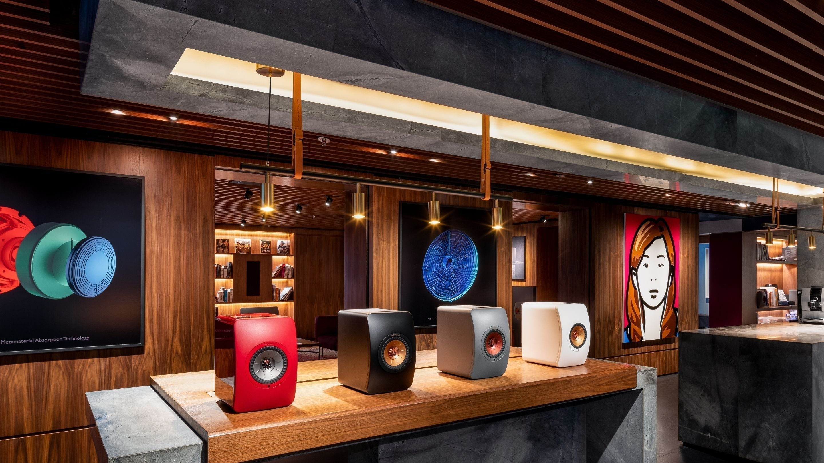 A store interior showcasing a wide array of KEF LS50 Wireless II speakers on display, highlighting various colours.
