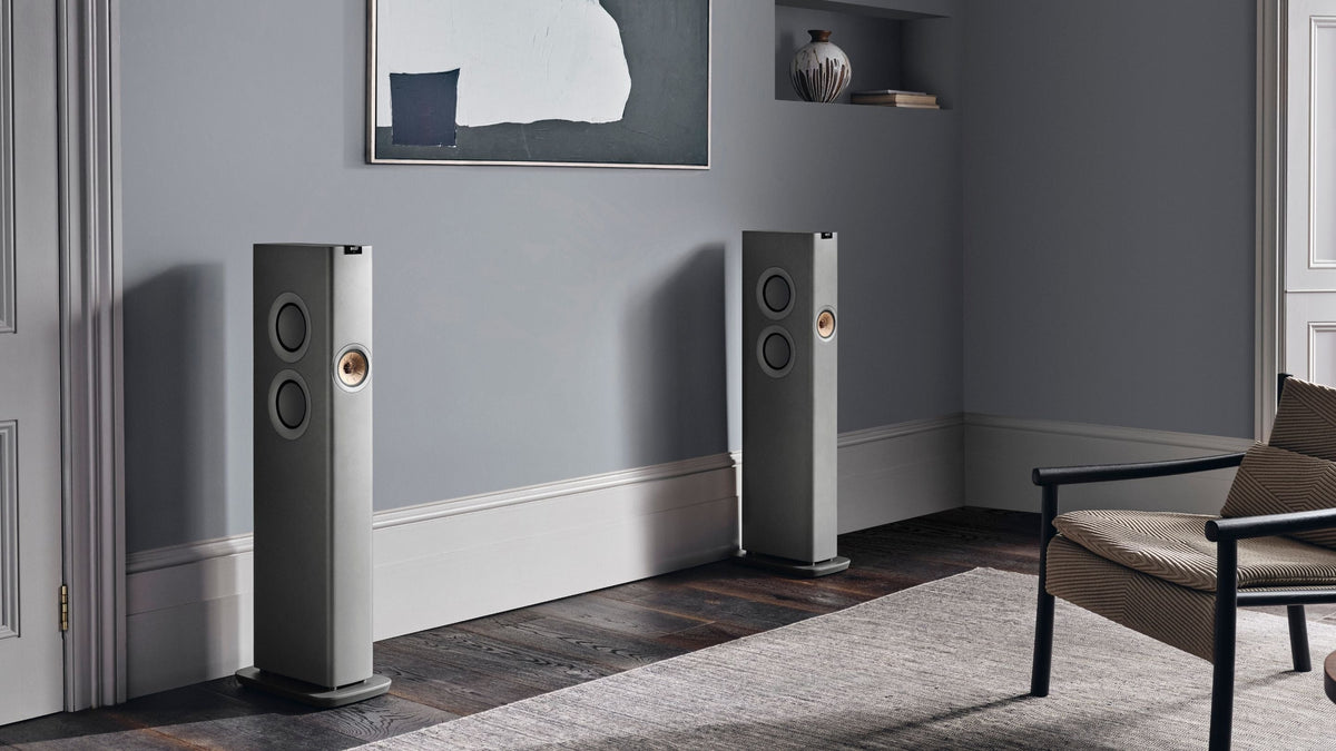 Modern interior with a wooden sideboard, decorative items, and KEF LS60 speakers.