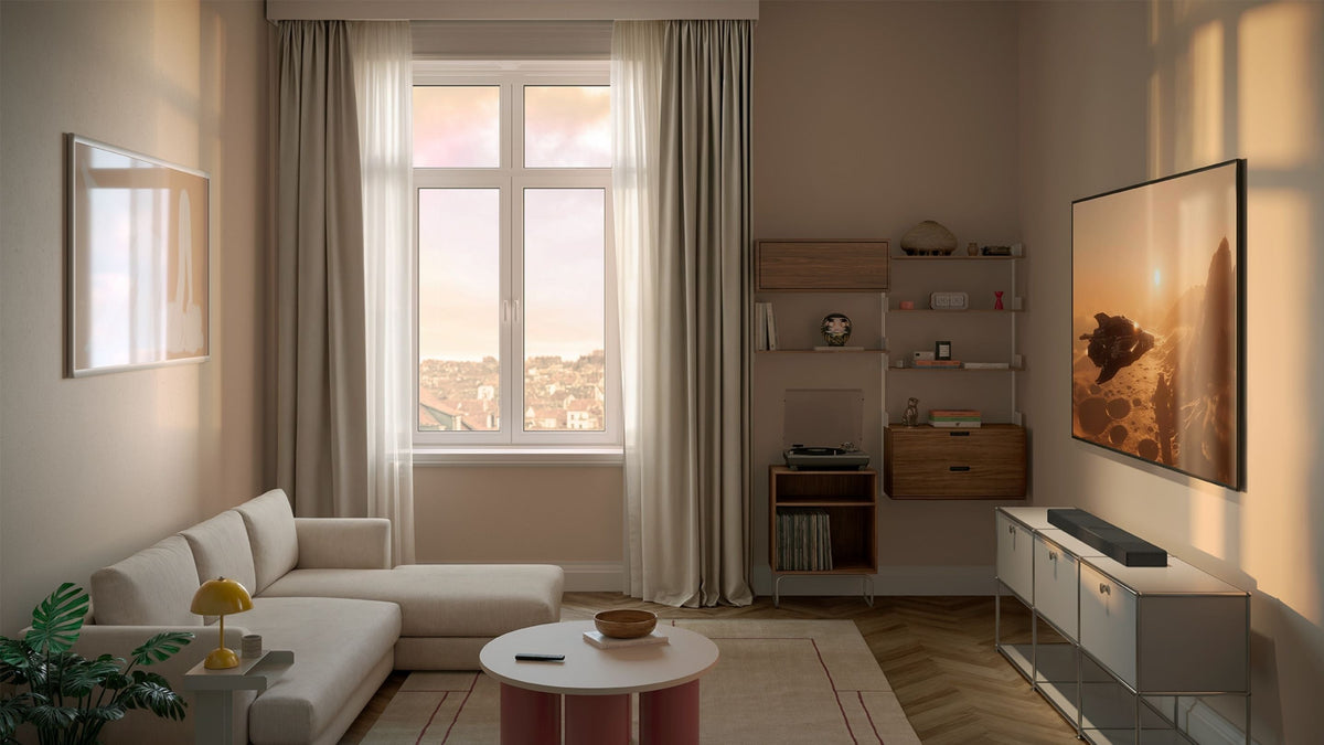 Modern living room with a large window, sofa, sideboard, TV & on the sidebaord there is a XIO soundbar placed on top of it.