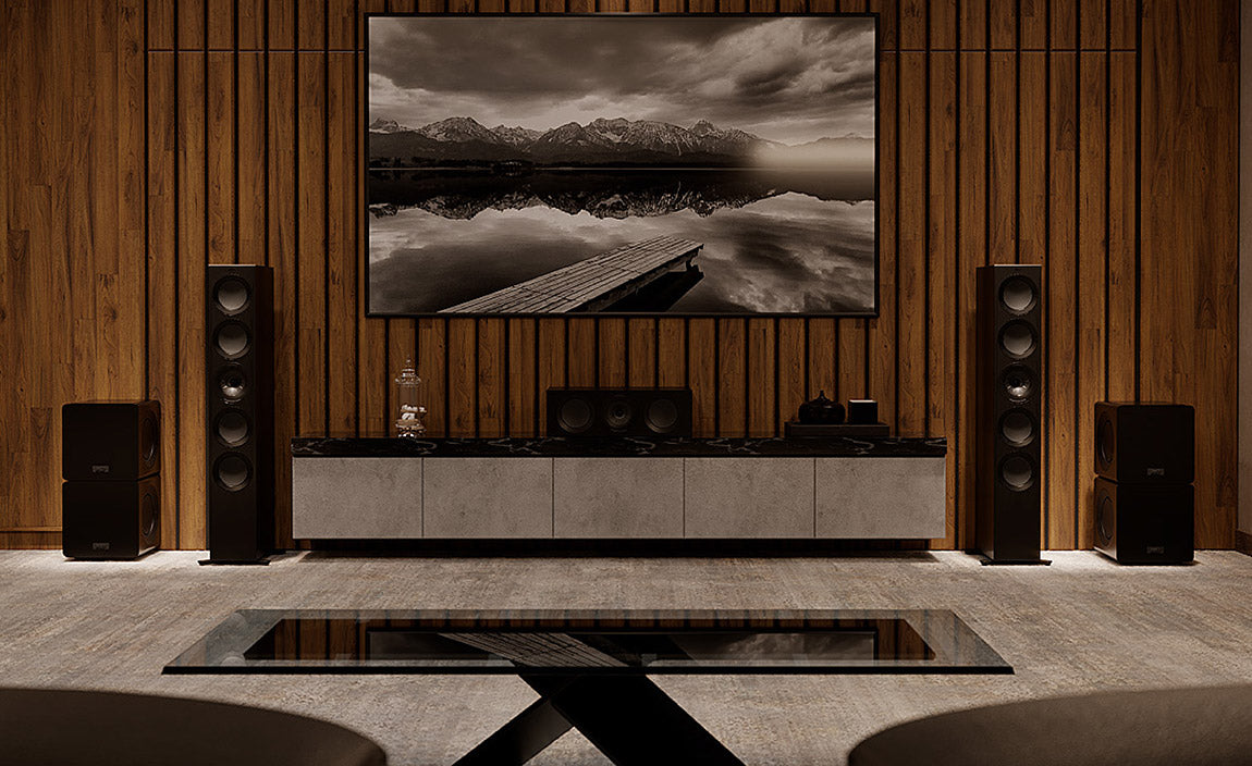 KEF R11 in gloss black and subwoofer stacks lifestyle image.